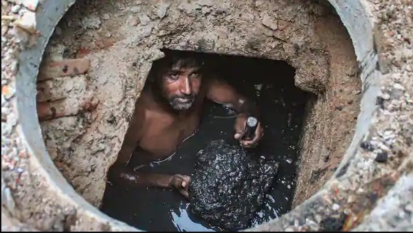 Men Cleaning Road Drainage System In India