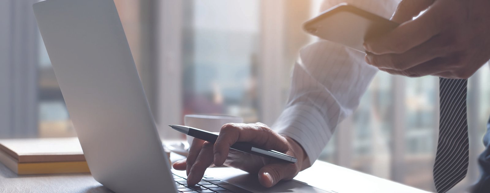 sharepoint intranet | close up of gentleman on his phone and computer